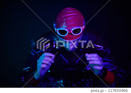 authentic triathlete swimmer having a break during hard training on night neon gel light authentic triathlete swimmer having a break during hard training on night neon gel light 117650966