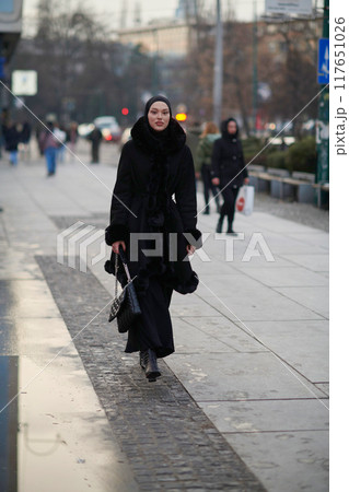 Muslim woman walking on an urban city street on a cold winter night wearing hijab Muslim woman walking on an urban city street on a cold winter night wearing hijab 117651026