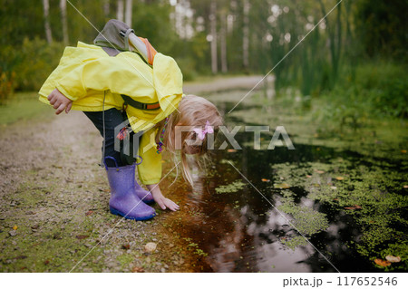 Active preschooler girl walking in the forest with backpack 117652546