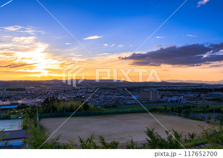 京都府最南端木津川市木津の街を望む高台からの夕景　山際を黄金色に染めながら生駒山系に沈ずむ夕日#8 117652700