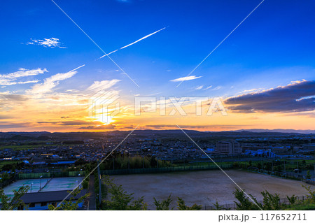 京都府最南端木津川市木津の街を望む高台からの夕景　山際を黄金色に染めながら生駒山系に沈ずむ夕日#19 117652711