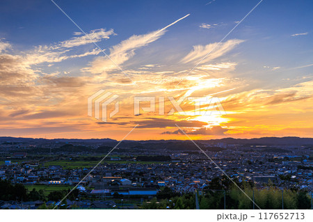 京都府最南端木津川市木津の街を望む高台からの夕景　山際を黄金色に染めながら生駒山系に沈ずむ夕日#21 117652713