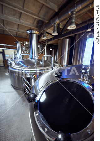 The stainless steel tanks in the brewery, with their advanced valves, highlight the technical expertise required in modern brewing. 117654436