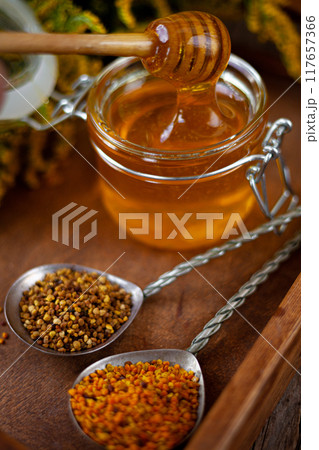 Bee honey and a wooden spoon. Sweet food. 117657366