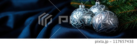 Three silver ornaments are on a blue background Three silver ornaments are on a blue background 117657438