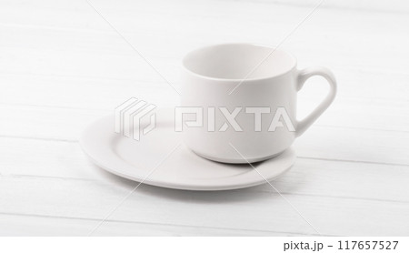 Cup standing on plate 117657527