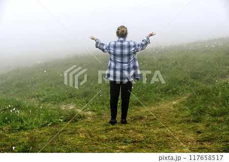 Caucasian woman has to choose the way in a foggy path Caucasian woman has to choose the way in a foggy path 117658517