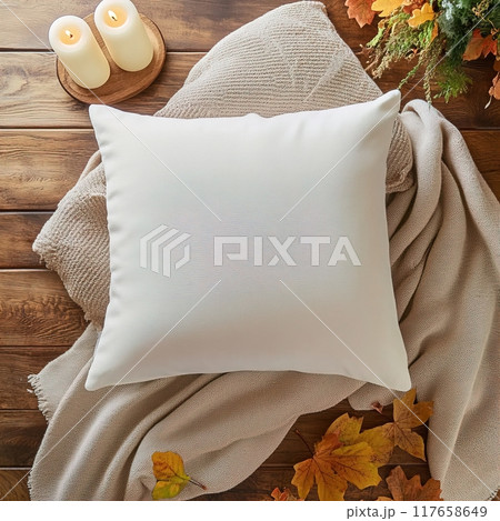 A Cozy Decorative Pillow placed softly on a Blanket adorned with vibrant Autumn Leaves White Square Pillow Mockup. 117658649