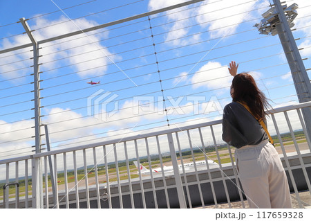 飛行機に手を振る女性の後ろ姿 117659328