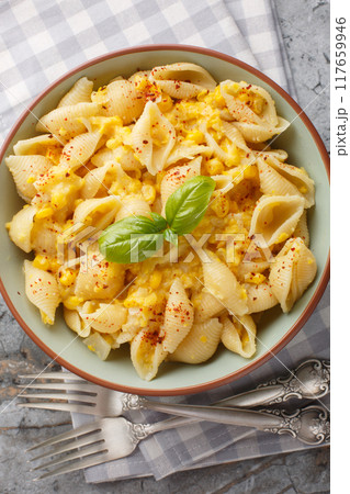 Vegetarian Conchiglie Pasta in cheesy corn sauce closeup in the bowl on the table. Vertical top view 117659946