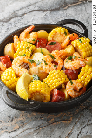 Classic shrimp boil that is a mixture of corn on the cob pieces, shrimp, smoked sausage and baby potatoes closeup. Vertical Classic shrimp boil that is a mixture of corn on the cob pieces, shrimp, smoked sausage and baby potatoes closeup. Vertical 117659963