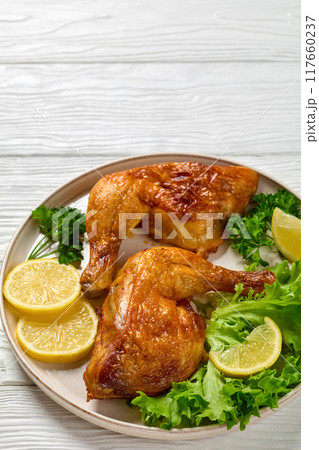 fried chicken legs with lettuce, lemon on plate fried chicken legs with lettuce, lemon on plate 117660237