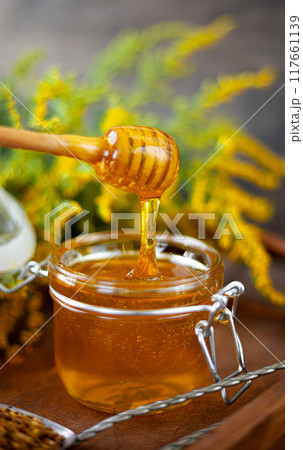 Fresh honey Bee product. Wooden spoon glass jar Fresh honey Bee product. Wooden spoon glass jar 117661139