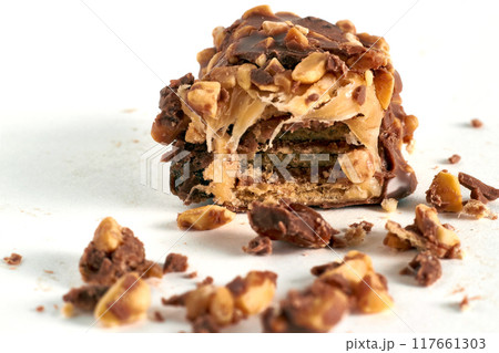 Wafer bar with soft caramel, covered with nuts and chocolate. Internal cross-section on the break Wafer bar with soft caramel, covered with nuts and chocolate. Internal cross-section on the break 117661303