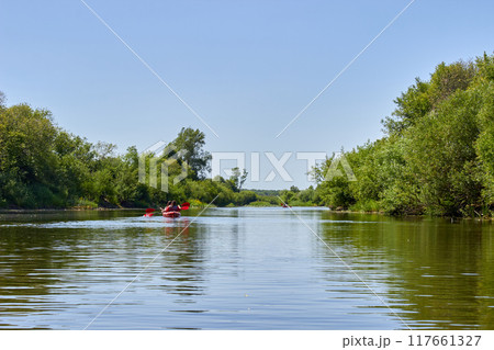 Kayaking on a picturesque river. Entertainment and recreation on a weekend Kayaking on a picturesque river. Entertainment and recreation on a weekend 117661327