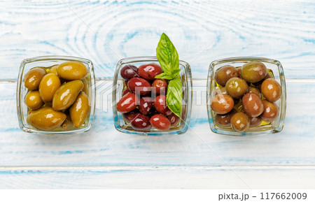 An assortment of various olives presented in a bowl, showcasing different colors, textures, and flavors An assortment of various olives presented in a bowl, showcasing different colors, textures, and flavors 117662009