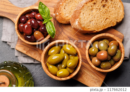 An assortment of various olives presented in a bowl, showcasing different colors, textures, and flavors An assortment of various olives presented in a bowl, showcasing different colors, textures, and flavors 117662012