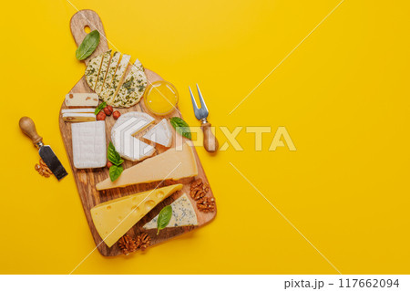 An assortment of various cheeses arranged on a board, highlighting different textures 117662094