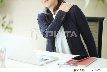オフィスで肩こりに悩むミドル女性 オフィスで肩こりに悩むミドル女性 117662568
