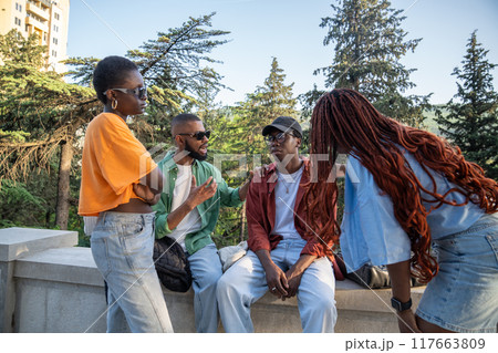 Sympathetic participating black friends students sitting together at park cheering on sad guy buddy. 117663809