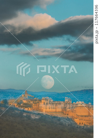 Jaipur, Rajasthan, India. Moon Rising Above Amer Fort Or Amber Fort, Amer, Rajasthan, India In sunset Time. Amer Palace Is Great Example Of Rajput Architecture. Amber Fort Principal Tourist Attraction Jaipur, Rajasthan, India. Moon Rising Above Amer Fort Or Amber Fort, Amer, Rajasthan, India In sunset Time. Amer Palace Is Great Example Of Rajput Architecture. Amber Fort Principal Tourist Attraction 117664396