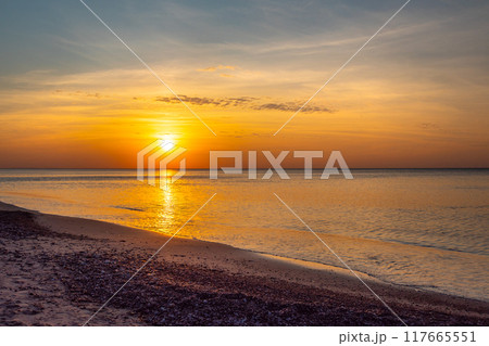 Sandy beach with pebbles of Baltic Sea on Curonian Spit at sunset. Kaliningrad region. Russia Sandy beach with pebbles of Baltic Sea on Curonian Spit at sunset. Kaliningrad region. Russia 117665551
