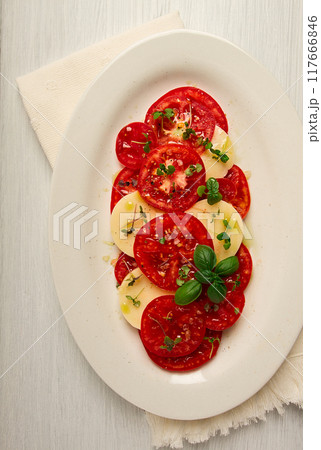 Caprese salad, Italian traditional dish, tomatoes with mozzarella cheese, basil and spices, top view, no people, Caprese salad, Italian traditional dish, tomatoes with mozzarella cheese, basil and spices, top view, no people, 117666846
