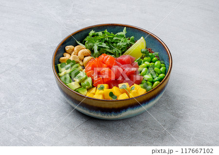 Top view of a colorful salmon poke bowl with fresh vegetables and rice, presented 117667102