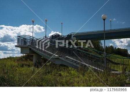 A pedestrian bridge over the highway. Steps for climbing the bridge A pedestrian bridge over the highway. Steps for climbing the bridge 117668966