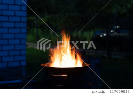 The fire is burning in the grill. A bonfire burning at night The fire is burning in the grill. A bonfire burning at night 117669032