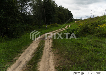 A rural, dirt road leading up. Cloudy sky A rural, dirt road leading up. Cloudy sky 117669059