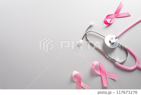 Pink ribbon and stethoscope on paper background for supporting breast cancer awareness month campaign. 117673276
