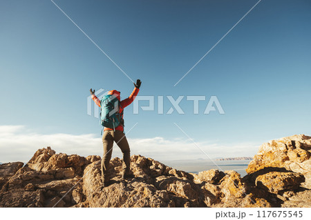 Woman hiker enjoy the view on mountain top cliff edge at lakeside 117675545