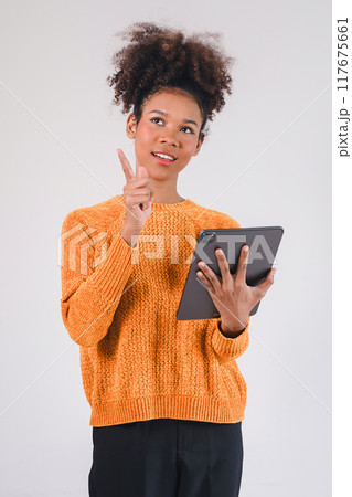 Smiling african american woman hand holding tablet and pointing upward. Isolated on white background. Smiling african american woman hand holding tablet and pointing upward. Isolated on white background. 117675661