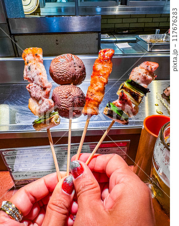 Yakitori meat skewers in a restaurant in Osaka, Japan 117676283
