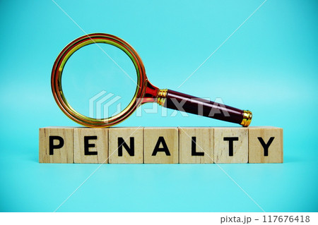 Penalty with wooden blocks alphabet letters and Magnifying glass on blue background Penalty with wooden blocks alphabet letters and Magnifying glass on blue background 117676418