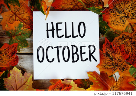 Hello October text with maple leaf decoration top view on wooden background 117676941