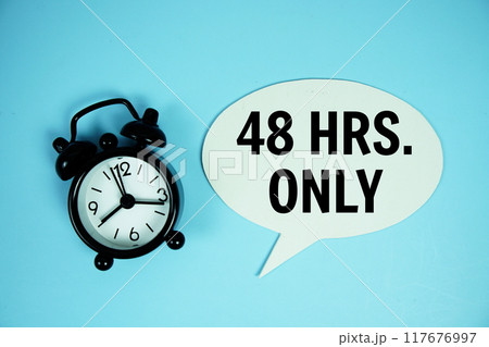 48 Hrs only text on speech bluble with alarm clock top view on blue background 117676997