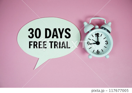 30 Days Free trial text on speech bluble with alarm clock top view on pink background 117677005