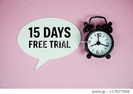 15 Days Free trial text on speech bluble with alarm clock top view on pink background 117677006