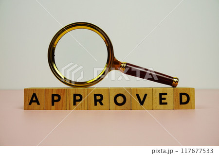 Magnifying glass with wooden blocks alphabet letters APPROVED on pink background Magnifying glass with wooden blocks alphabet letters APPROVED on pink background 117677533