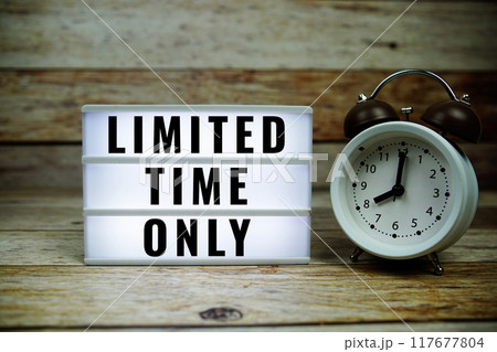 Limited Time Only text on LED lightbox with alarm clock on wooden background Limited Time Only text on LED lightbox with alarm clock on wooden background 117677804