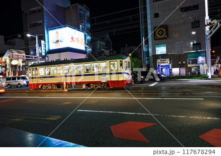 夜の高知市街を走る路面電車と市バス 117678294