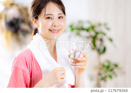 部屋で水を飲む若い女性 117679268