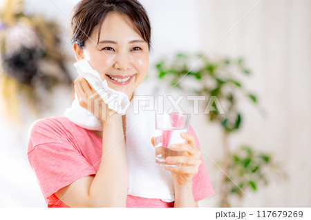 部屋で水を飲む若い女性 117679269