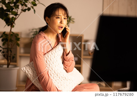 夜に電話をする若い女性 117679280