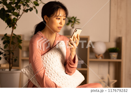 夜スマホを見る若い女性 117679282