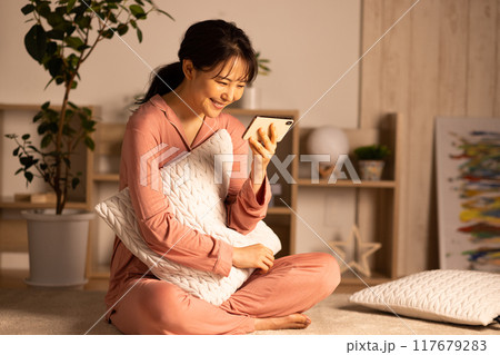 夜スマホを見る若い女性 117679283