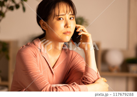 夜スマホを見る若い女性 117679288