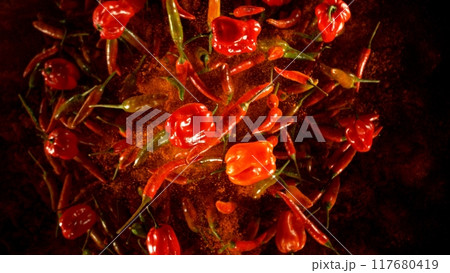 Group of coloured chilli peppers flying on black background. Group of coloured chilli peppers flying on black background. 117680419